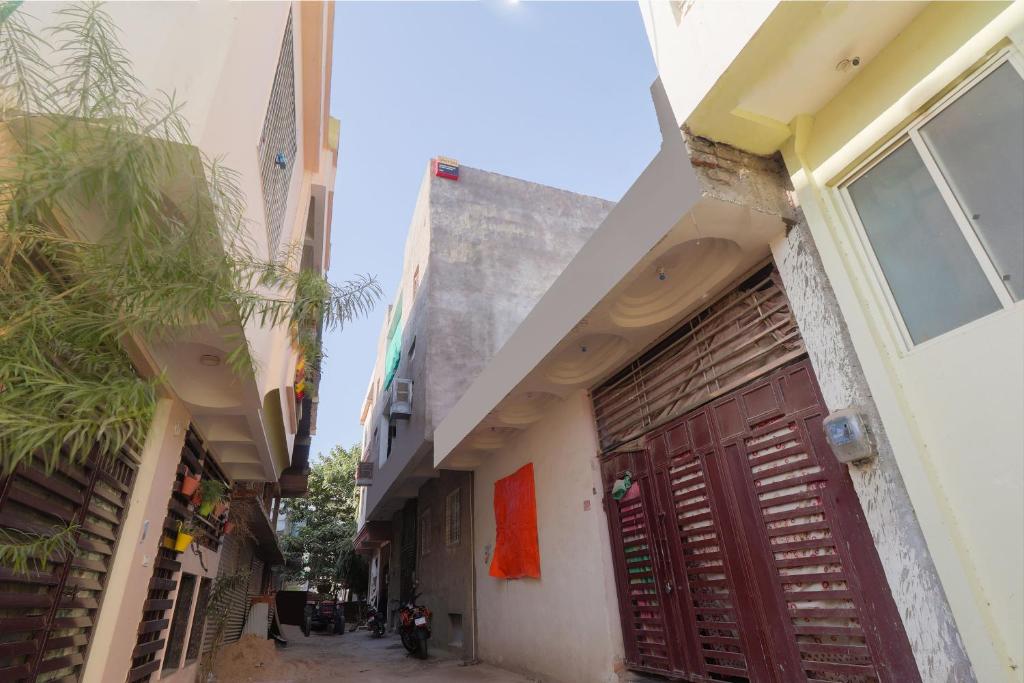 an alleyway between two buildings with a red door at OYO Siddhi Vinayak Guest House in Gwalior