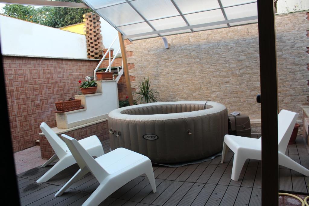 einen Whirlpool auf einer Terrasse mit weißen Stühlen in der Unterkunft Villa Severino Ferrari Anzio in Anzio