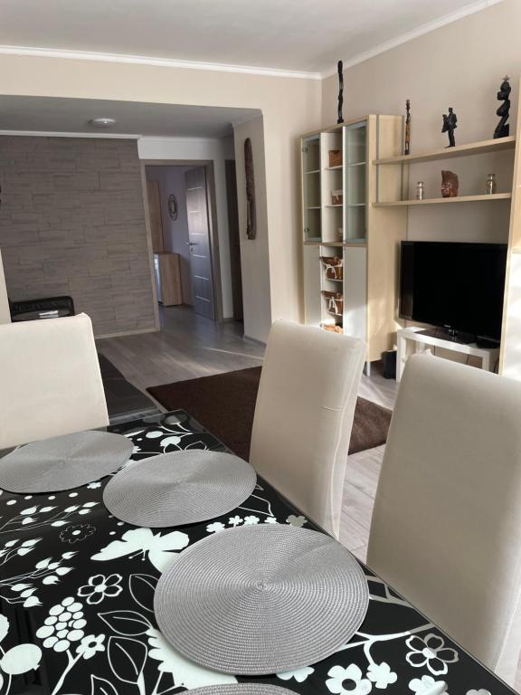 jadalnia ze stołem, krzesłami i telewizorem w obiekcie SunCity Apartman w Segedynie