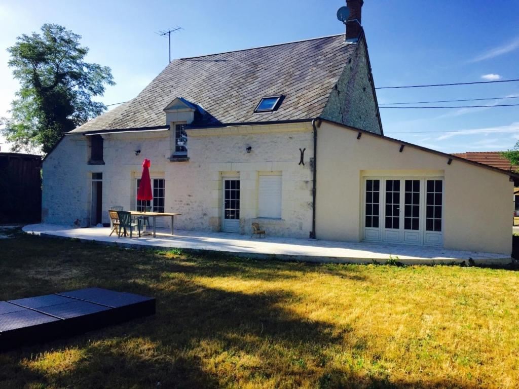 a white house with a table in a yard at Maison Coeur Nature pres du zoo beauval in Châtillon-sur-Cher