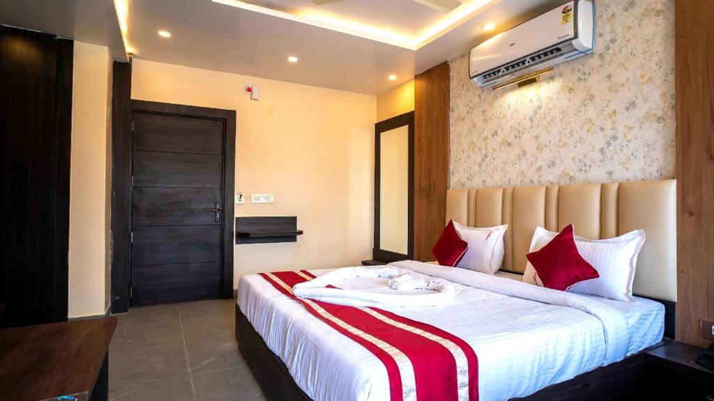 Pokój hotelowy z dużym łóżkiem z czerwonymi poduszkami w obiekcie N B Sonar Bangla Hotel w mieście Kalyani