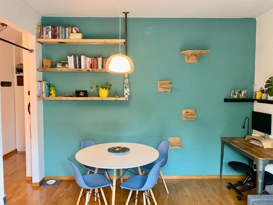 ブレシアにあるLa Tana: accogliente, romantica, relaxの青い壁の客室で、テーブルと椅子が備わります。