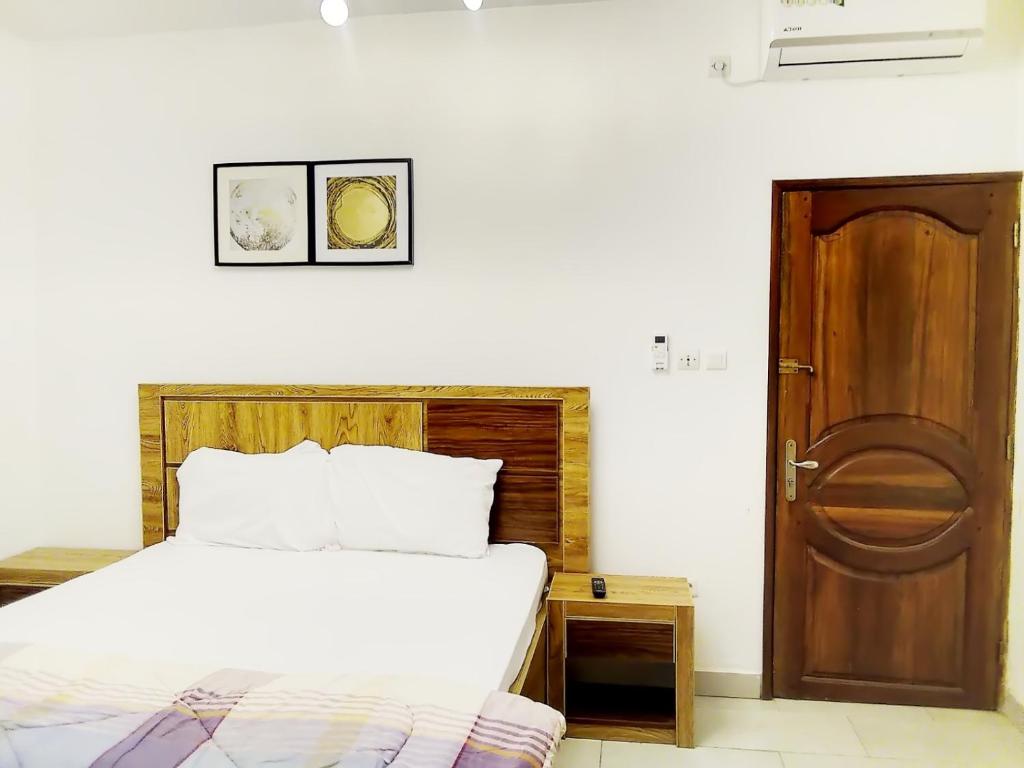 a bedroom with a bed and a wooden door at Keur Mina in Saint-Louis