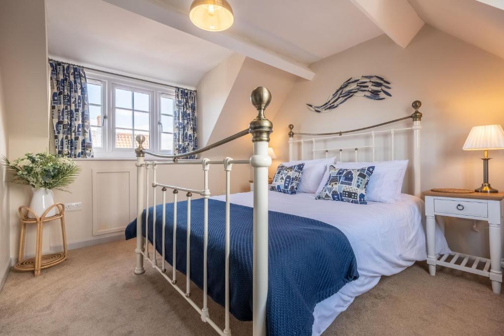 a bedroom with a white bed with a blue blanket at Sea Haven in Wells next the Sea