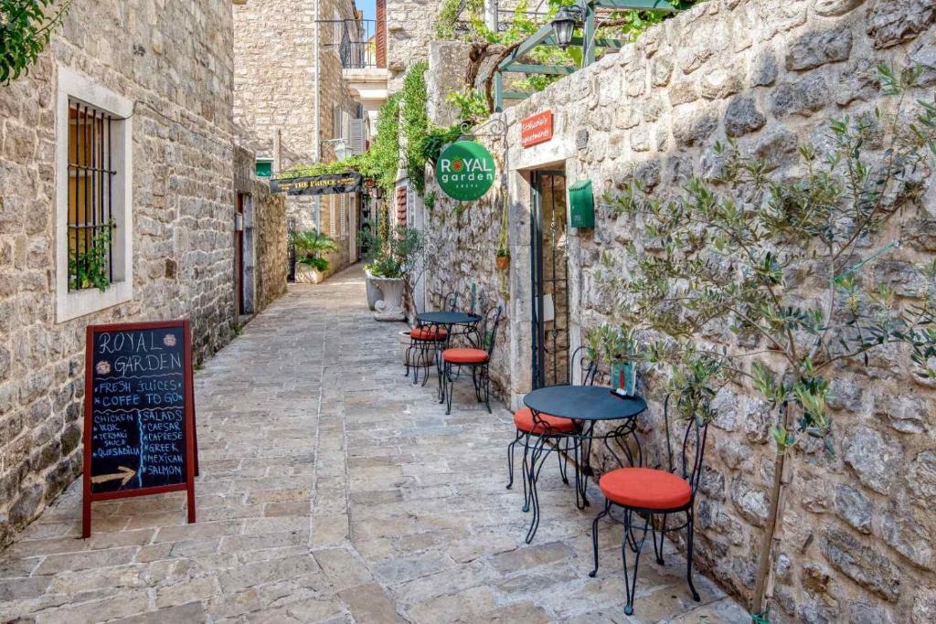a group of tables and stools outside a building at Royal Garden Apartments & Gastronomy in Budva