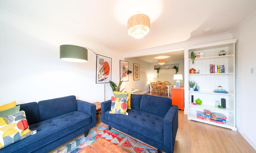 uma sala de estar com dois sofás azuis e uma cozinha em Westland Shores em Crail