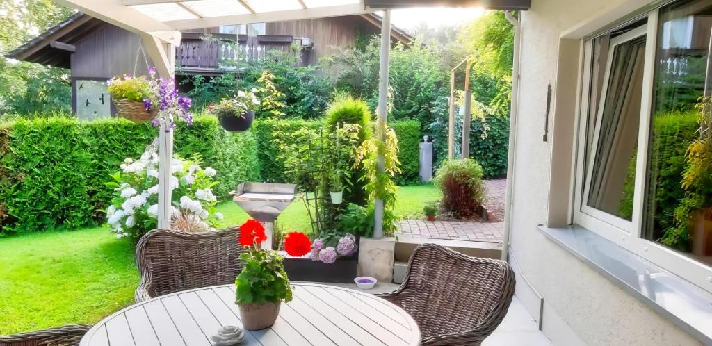 eine Terrasse mit einem Tisch, Stühlen und Blumen in der Unterkunft Ferienwohnung Lieblingsplatz mit Terrasse in Balve