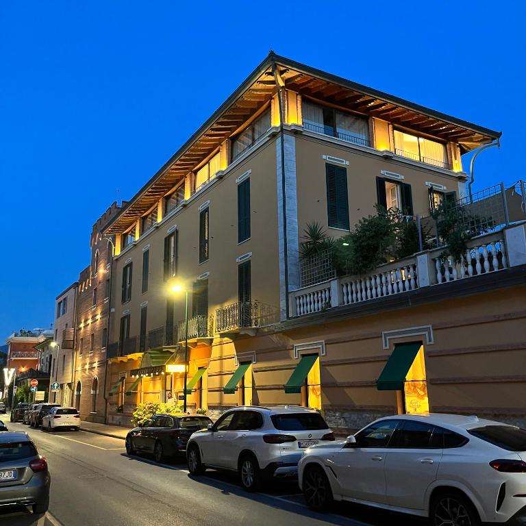 a building with cars parked on the side of a street at Hotel Regina in Forte dei Marmi