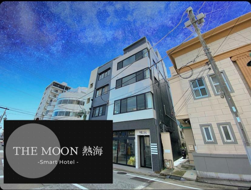 un edificio con una señal delante de él en THE MOON Atami en Atami