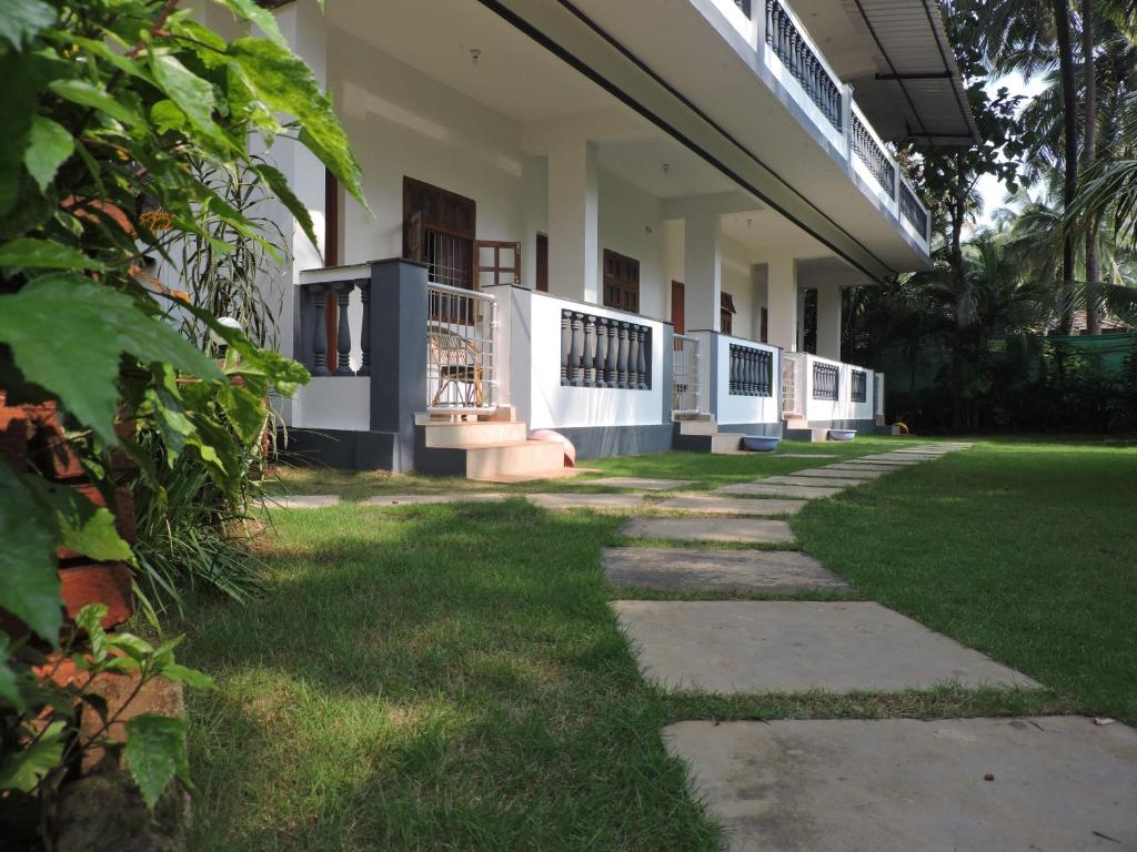 a building with a walkway in front of a yard at Abba's Glory Land - Agonda in Agonda