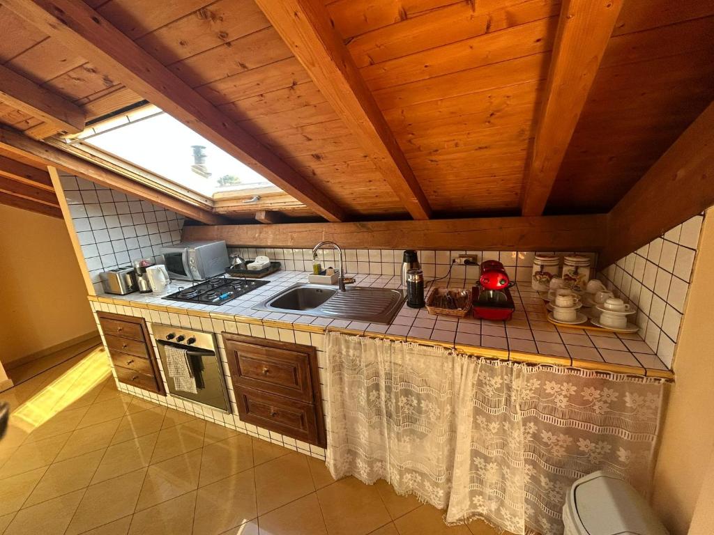 een keuken met een wastafel, een fornuis en een raam bij RAMO FIORITO in Sant’Agata Li Battiati 