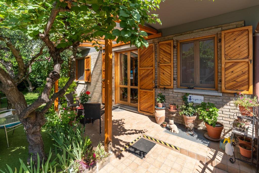 a house with wooden doors and a patio with potted plants at B&B La Gatta Blu in Cattolica