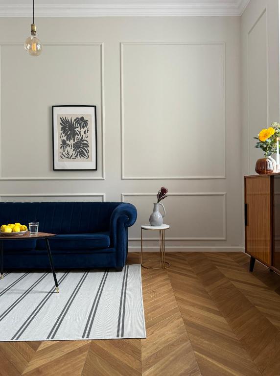 a living room with a blue couch and a table at Wilson Apartamenty in Poznań