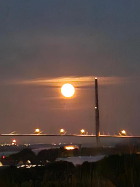 Une grande lune dans le ciel la nuit dans l'établissement NIGHT & DAY, à Honfleur