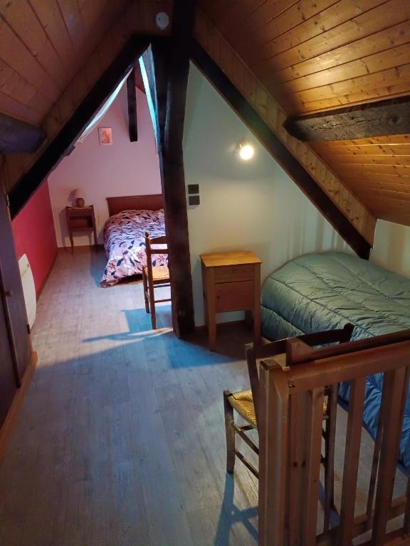 a attic room with a bed and a table at Piet in Laruns