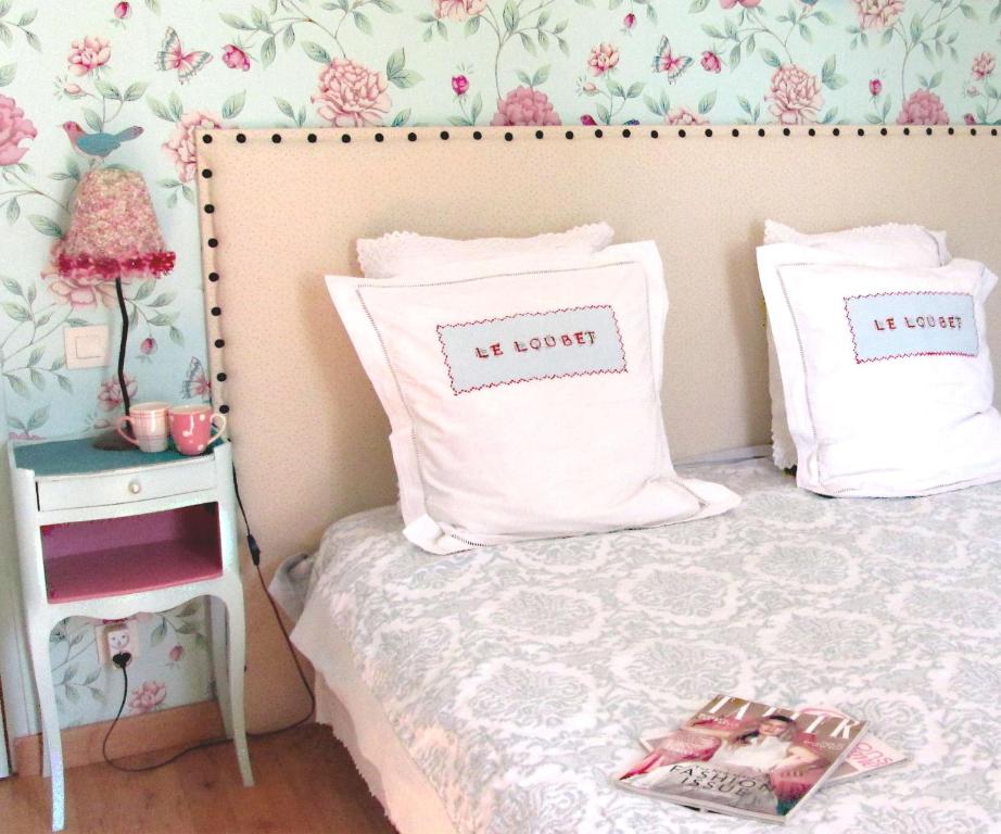 a small bedroom with a bed with two pillows at Chambres d'Hôtes Le Loubet in LʼIsle-Jourdain