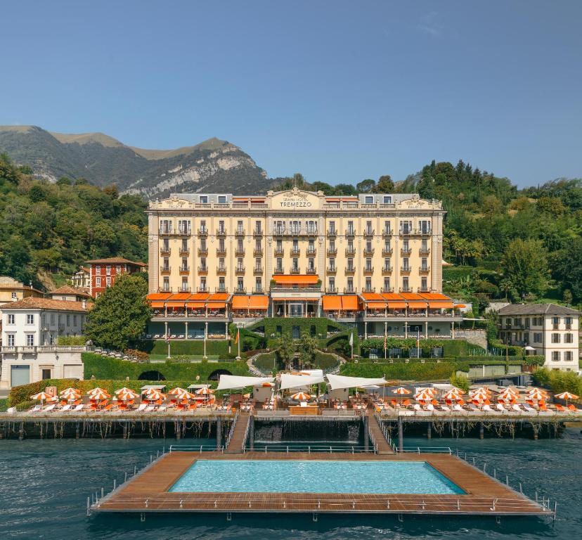 a large building with a pool in the water at Grand Hotel Tremezzo in Tremezzo