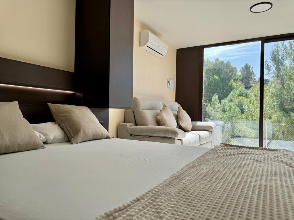 a bedroom with a bed and a couch and a window at Camping Fonts del Algar in Callosa d'en Sarrià