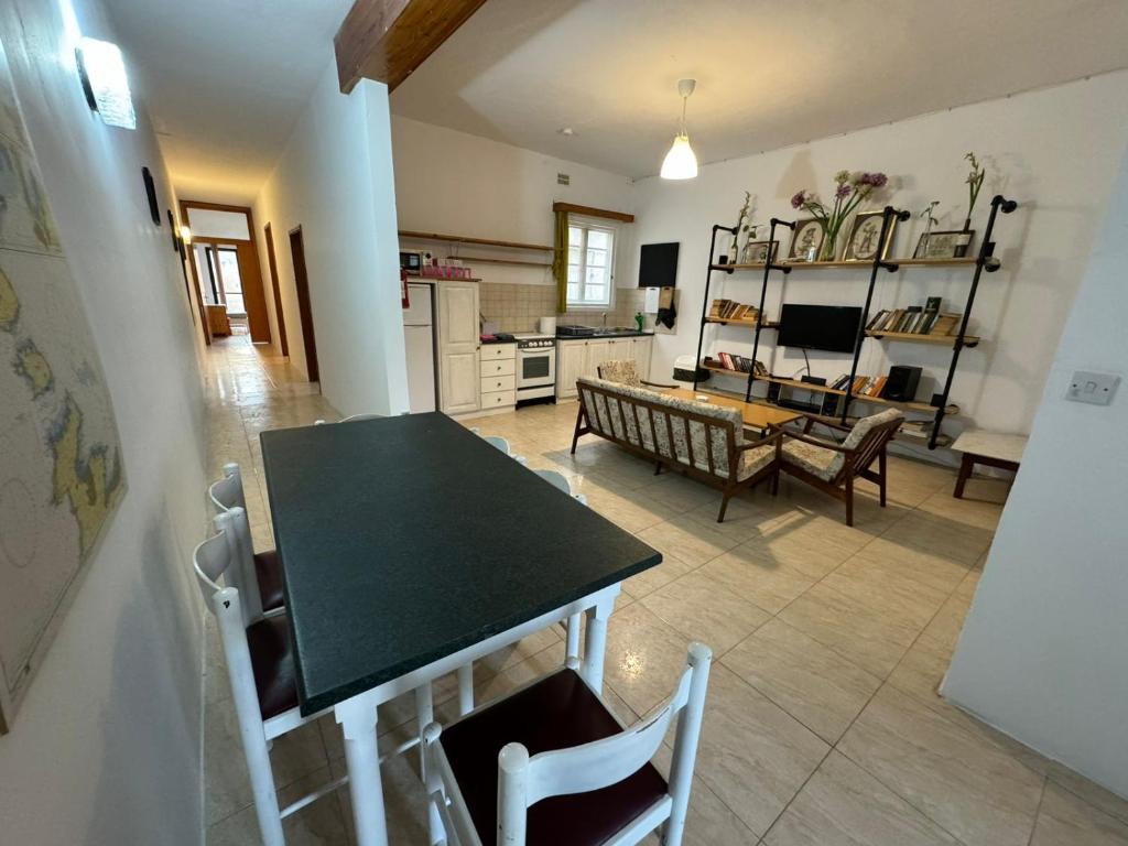 cocina y sala de estar con mesa y sillas en Paradise 4 en Żebbuġ