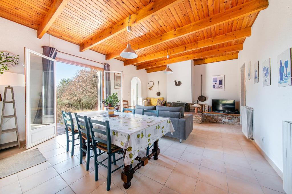 un grand salon avec une table et des chaises dans l'établissement Les Olivettes - Maison très calme Parking privé, à Régusse