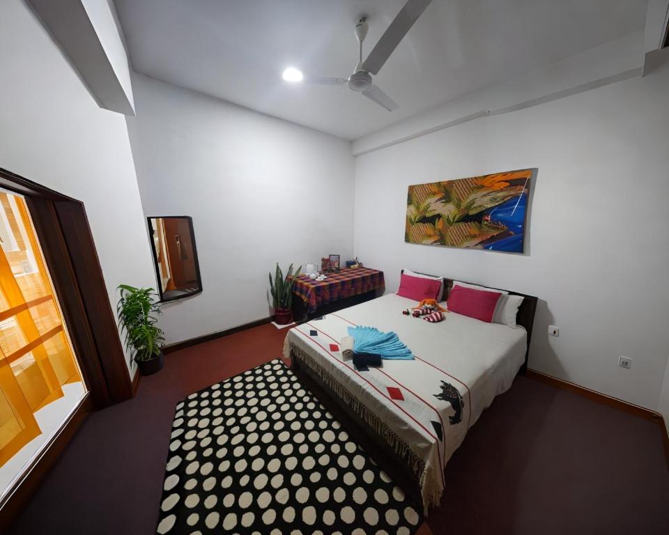 a bedroom with a bed and a painting on the wall at Villa kresilda in Gampola