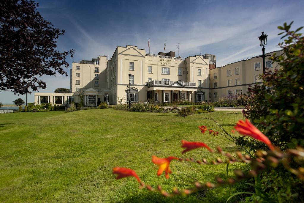 a large white building on a field of grass at Grand Hotel in Malahide