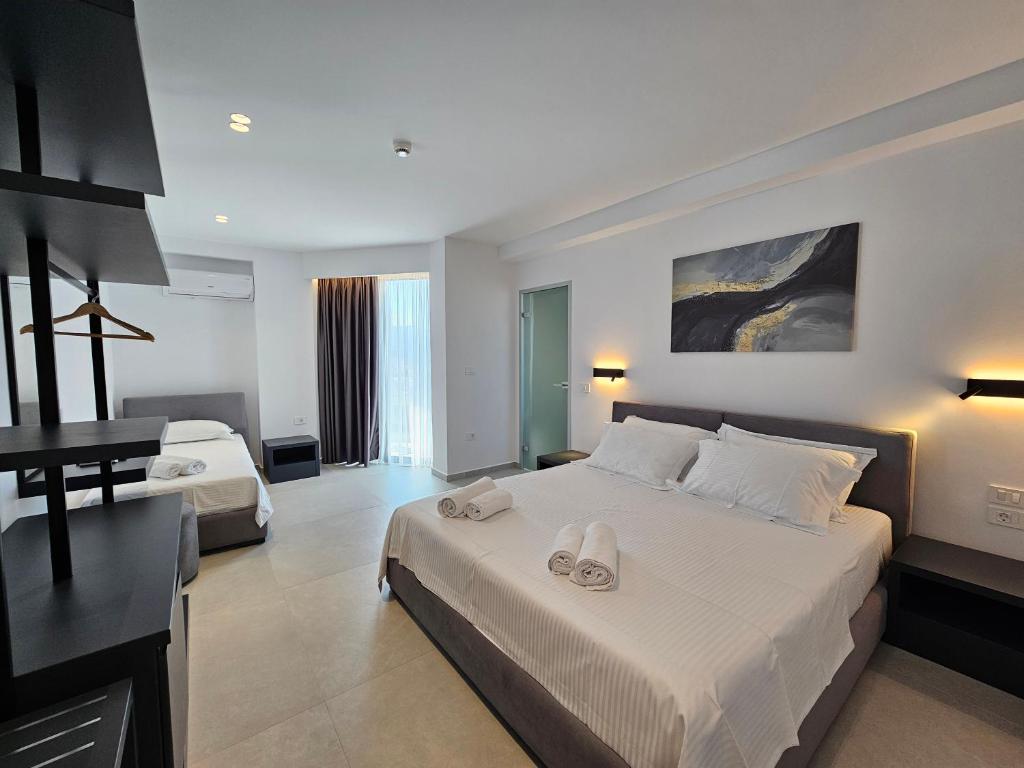 a bedroom with a large white bed with two shoes on it at Adele Hotel Ksamil in Ksamil