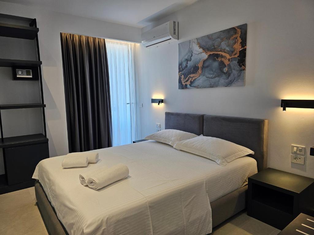 a bedroom with a bed with two towels on it at Adele Hotel Ksamil in Ksamil