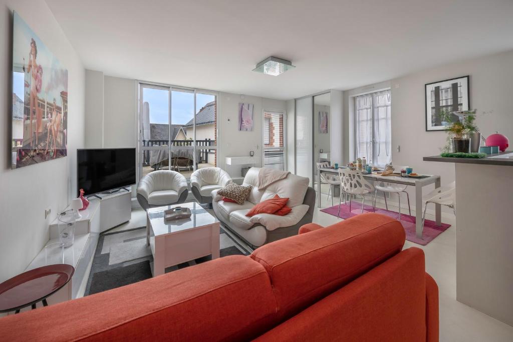 un salon avec un canapé rouge et une table dans l'établissement 200m du Port du Pouliguen - 700m plage du Nau, au Pouliguen