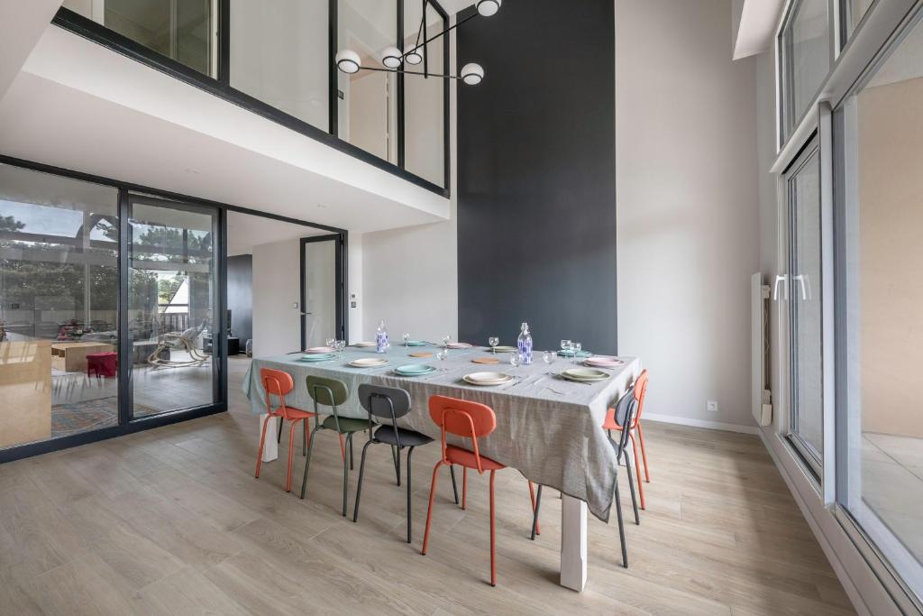 une salle à manger avec une table et des chaises orange dans l'établissement Triplex pour 12 - 400m de la plage des Libraires, à Pornichet