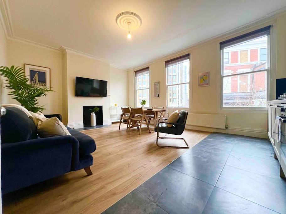 a living room with a blue couch and a table at 4 Bed Apartment- Archway Station in London
