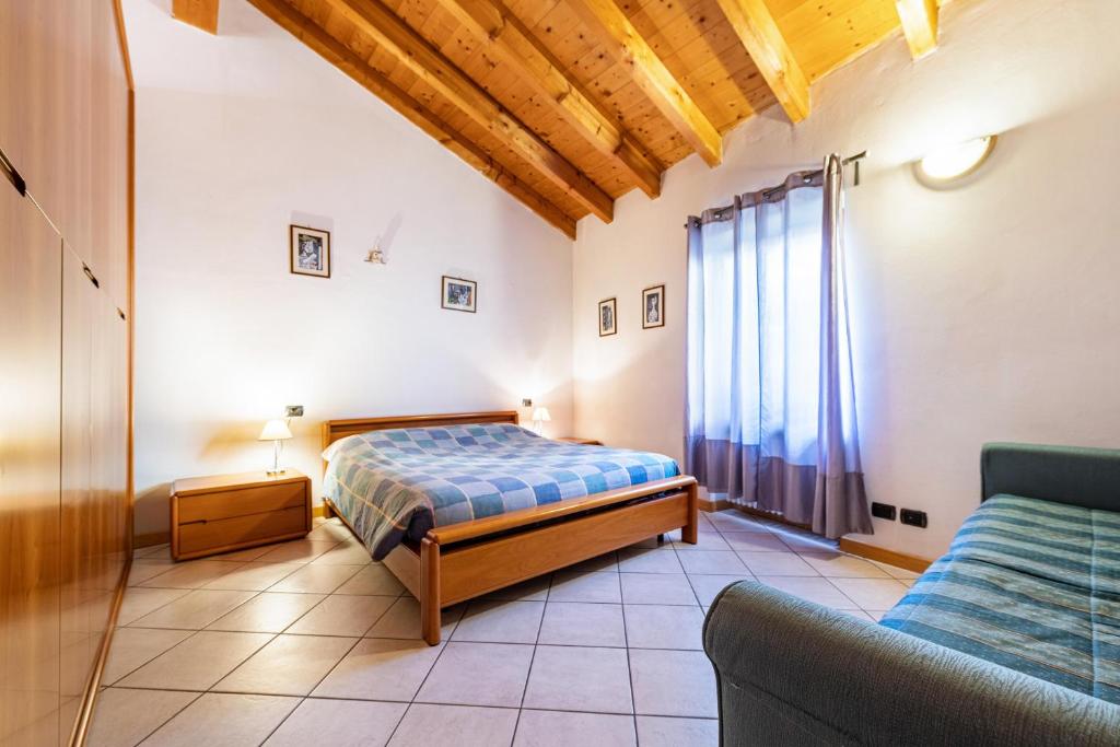 1 dormitorio con 1 cama y 1 sofá en Casella's apartment 1, en Malcesine