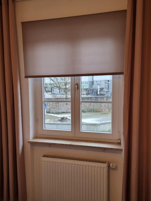 una ventana con un ciego en una habitación con radiador en BK City Apartments, en Backnang