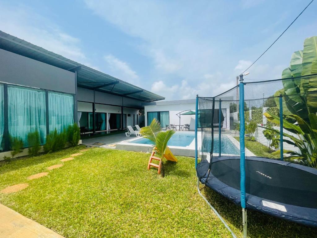 een achtertuin met een zwembad en een huis bij Les merveilles d’assinie in Assinie