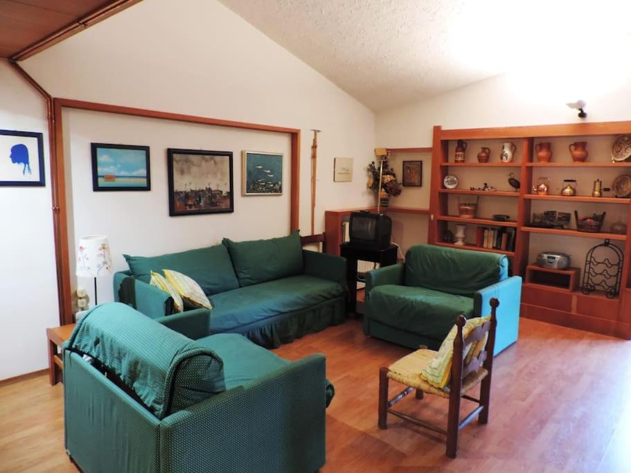 ein Wohnzimmer mit 2 grünen Sofas in der Unterkunft Appartamento per 6 nel Residence La Ginestra in Pescasseroli