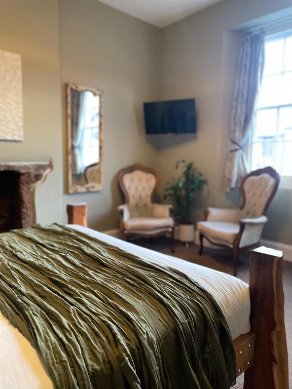 ein Schlafzimmer mit Bett und ein Wohnzimmer in der Unterkunft The Roost in Cullompton