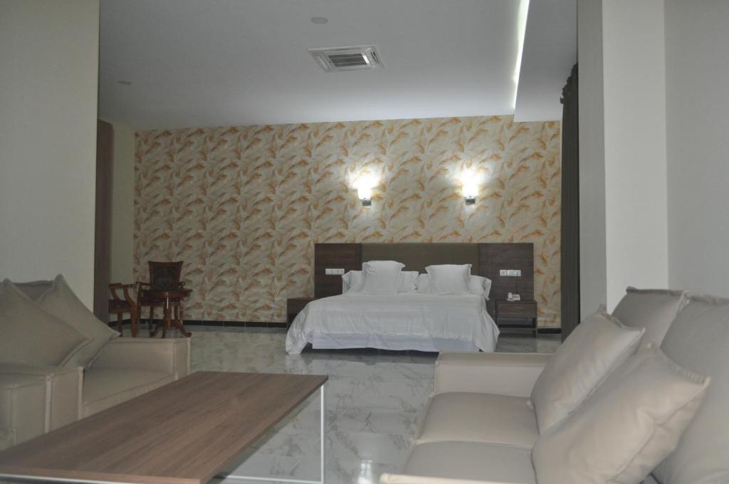 ein Wohnzimmer mit einem Bett und einem Sofa in der Unterkunft Hôtel Lina in Bordj Bou Arreridj