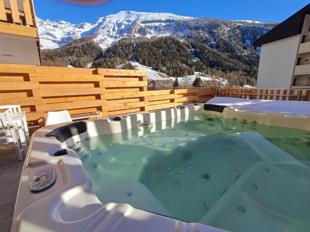 a hot tub on a balcony with a mountain at Spacieux appart 3,5 pièces incl Jaccuzzi Privé in Leukerbad