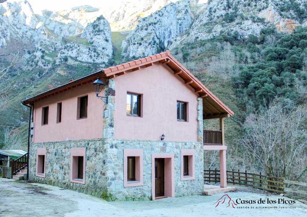 una pequeña casa frente a una montaña en Apartamento rural Karibu 2 San Esteban by Casas de Los Picos Ecoturismo en los Picos de Europa, en San Esteban