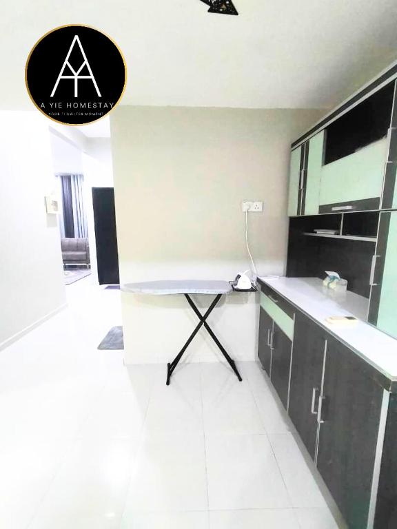 a kitchen with a counter and a table in a room at A YIE HOMESTAY in Kuantan