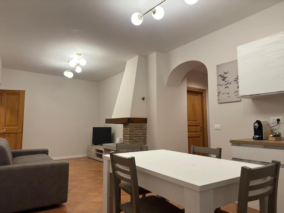 a kitchen and living room with a table and chairs at Fronte lago nel centro storico “La Casa del Lago” in Trevignano Romano