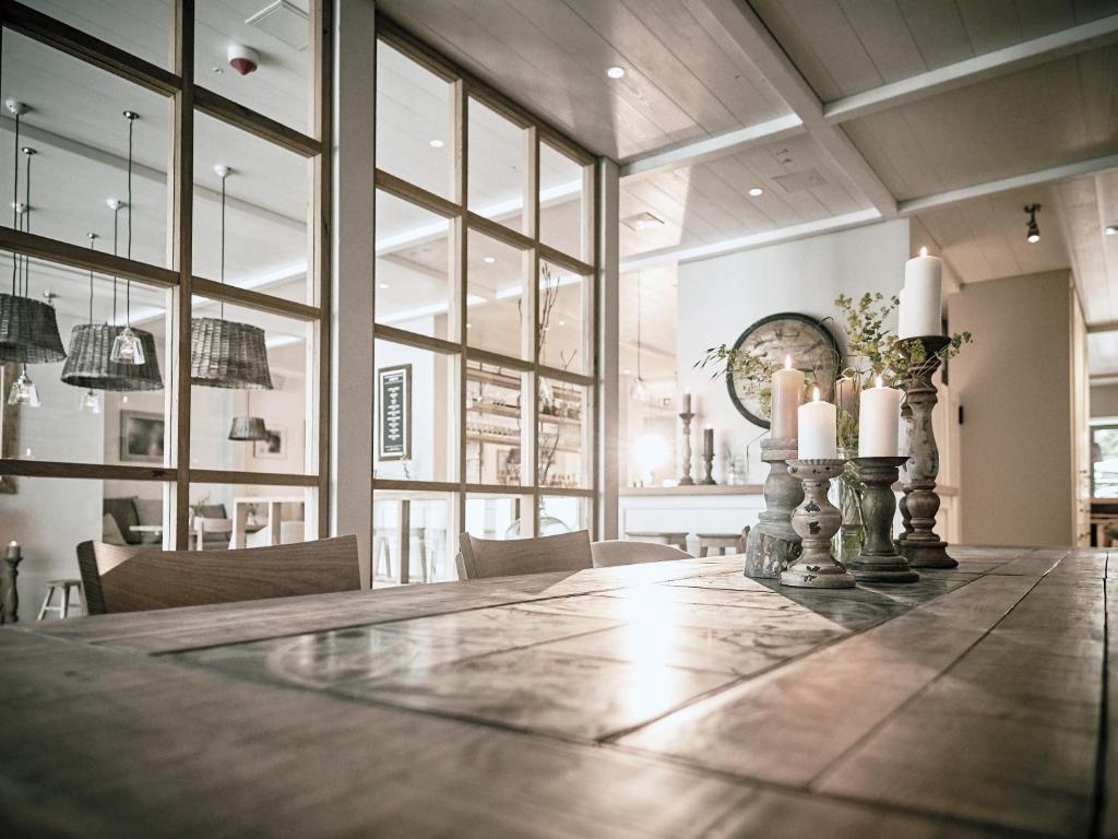 a large dining room with a long table with candles at The Cozy Hotel & Lofts Timmendorfer Strand in Timmendorfer Strand