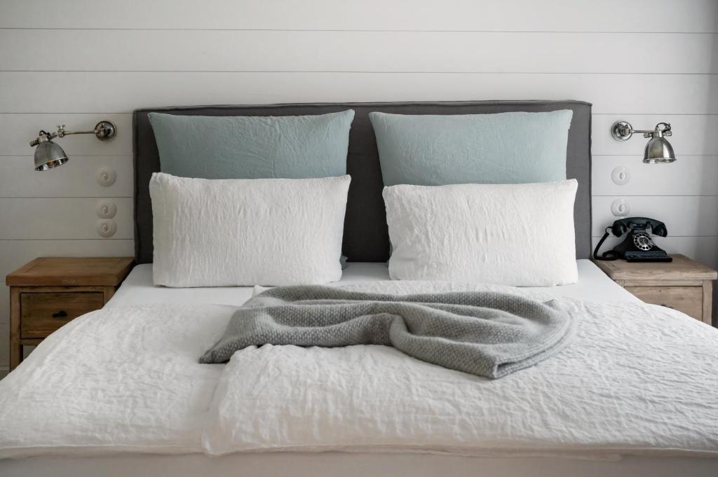 a white bed with a blanket and pillows at The Cozy Hotel & Lofts Timmendorfer Strand in Timmendorfer Strand