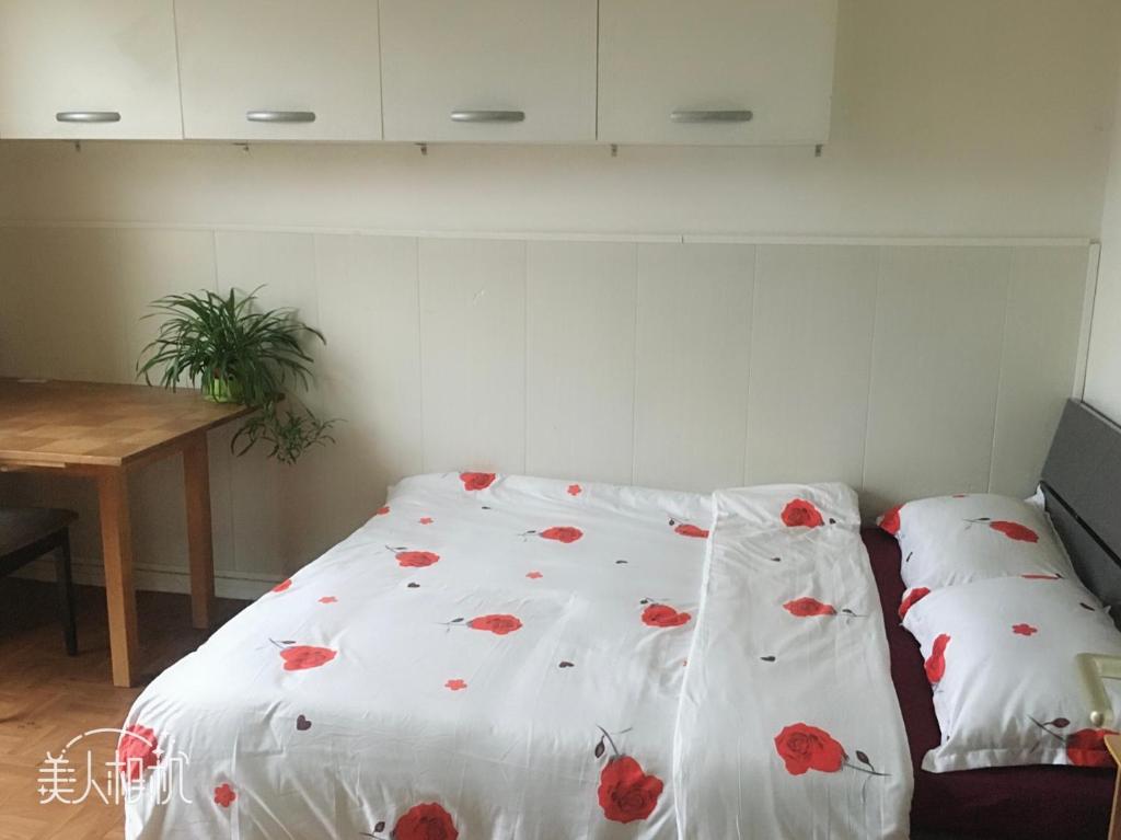 Un dormitorio con una cama con flores rojas. en Chambre ensoleillée et lumineuse en Orly