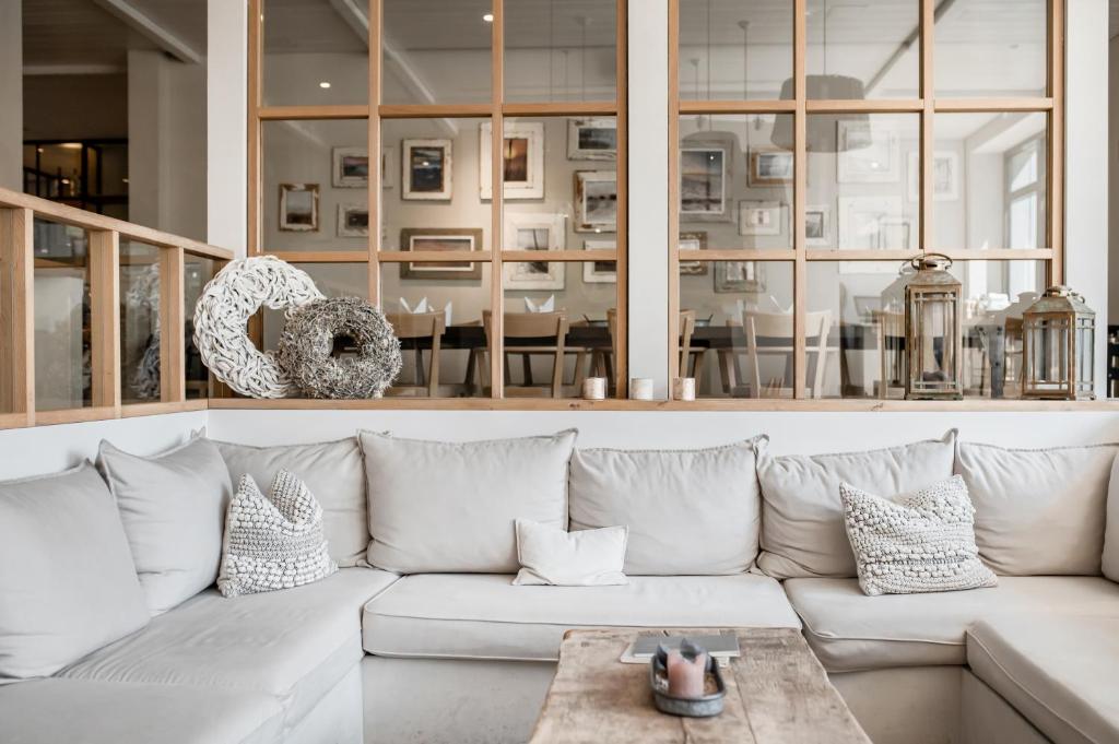 a living room with a white couch and a table at The Cozy Hotel & Lofts Timmendorfer Strand in Timmendorfer Strand