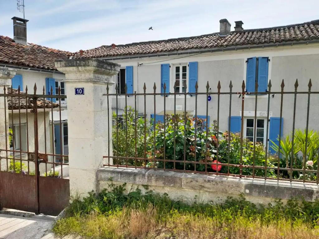 une clôture devant une maison aux volets bleus dans l'établissement Les Hirondelles Archiac, à Archiac