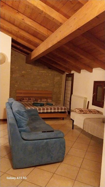 een woonkamer met een bank en een bed bij La corte dei celti la fonte 1 in San Benedetto Del Querceto