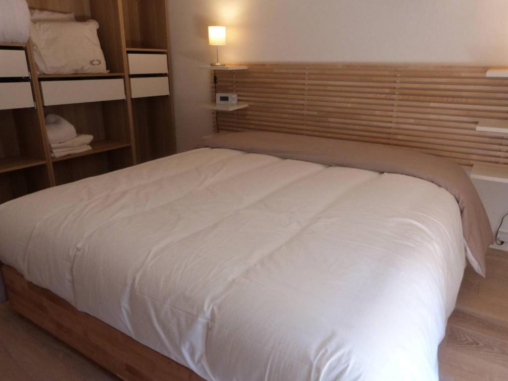 a bedroom with a large white bed with a window at GASETIENNE Mazet T2 dans domaine avec piscines et tennis in Gassin