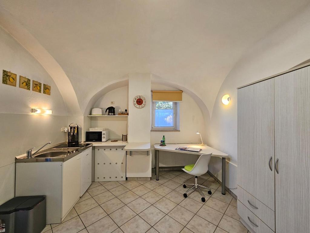 a kitchen with a table and a desk in a room at Tiny central studio apartment Tour As Ljubljana in Ljubljana