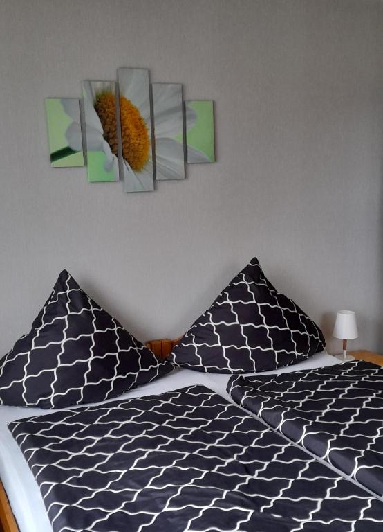 a bedroom with a bed with two paintings on the wall at Apartments Panoramablick in Geislingen an der Steige